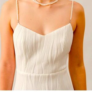 Elegant white dress with pearls, never worn. Fits exactly the size.